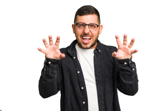 Young caucasian man isolated showing claws imitating a cat, aggressive gesture.