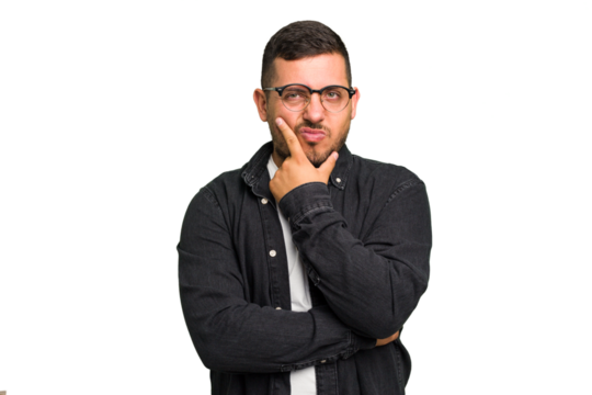 Young caucasian man isolated contemplating, planning a strategy, thinking about the way of a business.