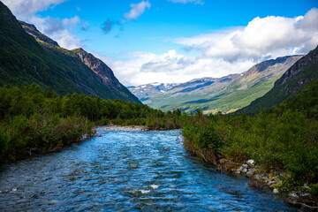 Fototapeta na wymiar a rushing river flowing through the mountains in northern norway, lyngenfjord; the rugged landscape of the norwegian fjords