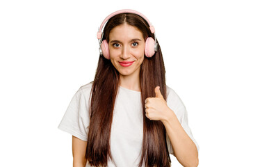 Young caucasian woman wearing headphones isolated smiling and raising thumb up