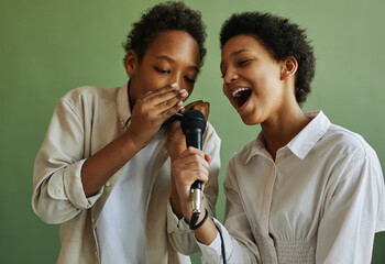 Youthful African American boy and girl performing song together during repetition while playing...
