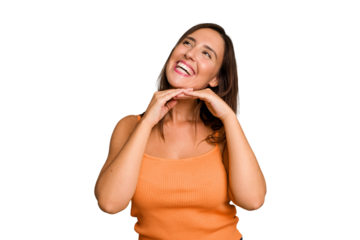 Young caucasian cute woman isolated keeps hands under chin, is looking happily aside.