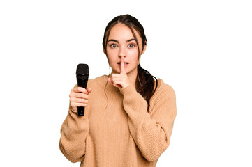 Young caucasian singer woman isolated on green chroma background keeping a secret or asking for silence.