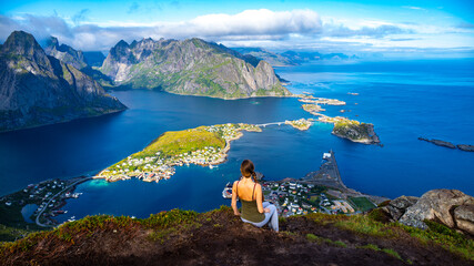  beautiful girl enjoys the panorama of lofoten islands in norway from the famous reinebringen...