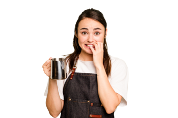 Young barista woman isolated on green chroma background biting fingernails, nervous and very anxious.