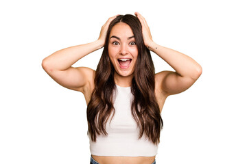 Young caucasian woman isolated on green chroma background screaming, very excited, passionate,...