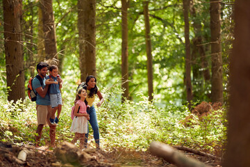 Naklejka na ściany i meble Family With Backpacks Hiking Or Walking Through Woodland Countryside