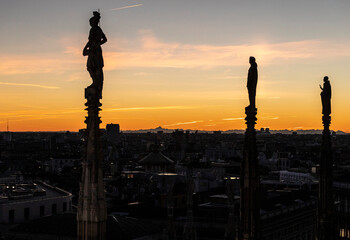 Fototapeta na wymiar Statues of Milan Cathedral at sunset, Statue del Duomo di Milano al tramonto, Italy.