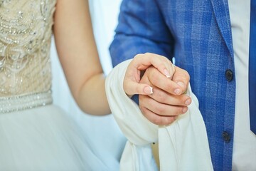 The hands of the bride and groom. Wedding ceremony or engagement celebration.