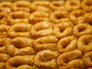 baklava rolls nest, oriental dessert made of phyllo, nuts, butter and syrup served on tray. Traditional turkish, arabic, jewish sweet. Full frame background, top view.