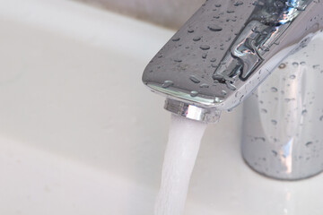 Water faucet. Water flow in the bathroom Modern clean house.