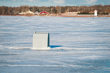 Ice fishing on a frozen harbor in rural Prince Edward Island, Canada.