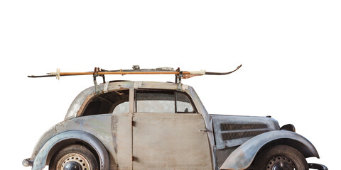 Vintage weathered car with skis attached to a roof rack isolated on a white background