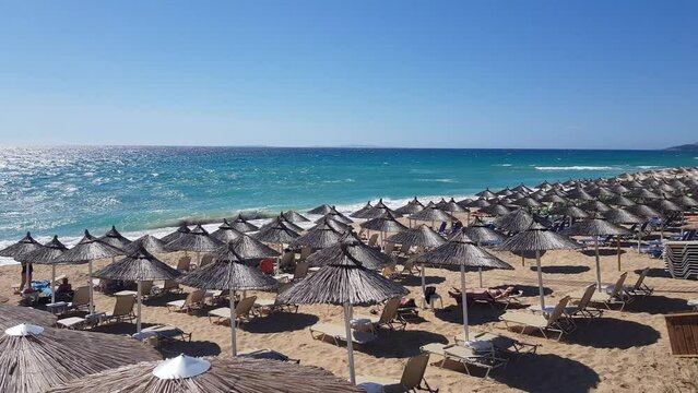 A beautiful sandy Mediterranean beach with rows of reed umbrellas