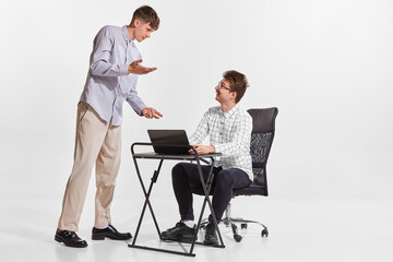 Portrait of two men. IT specialist working together, mentor giving help to employee isolated over...