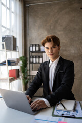 Male office worker browsing in laptop for necessary information