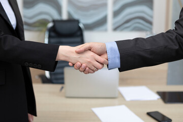 Business people shaking hands and finishing up the meeting. Contract and business deal concept.	