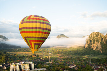 Aerial view of the sunrise at the city with a Hot Air Balloon at Vang Vieng Laos. Adventure concept. Tourism in Vang Vieng, Laos.