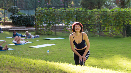 Beautiful woman walking on the grass after yoga class.