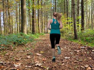 Junge Frau joggt im herbstlichen Wald