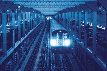 New York City subway car traveling across the Williamsburg Bridge between Brooklyn and Manhattan with blue monotone color - obrazy, fototapety, plakaty