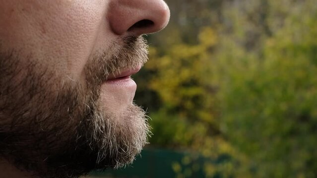 Smoking disposable electronic cigarettes outdoor . Closeup of bearded man, concept of modern alternative  smoking, vaping and nicotine.