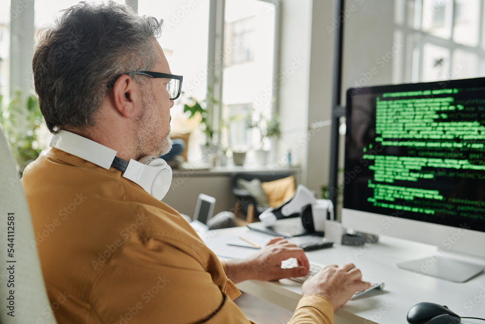 Aufkleber Selective focus on mature IT engineer decoding information on computer screen while sitting in front of monitor in coworking space