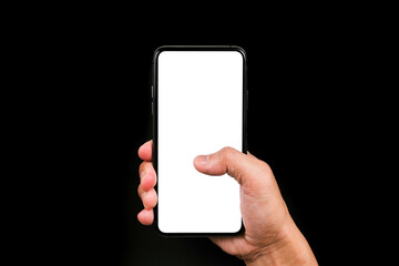 Hand holding the mobile phone and using the thumb to touch the screen in white with isolated black background.  Hand & mobile phone close up shot.