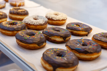 Fresh sweet donut in white and chocolate glaze are on the shelf