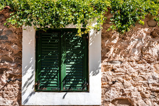 Fen&ecirc;tre avec volets clos et mur ensoleill&eacute; &agrave; Pag en Croatie