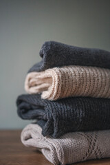 Stack of warm cozy sweaters in neutral gray and beige shades