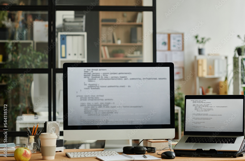 Poster Workplace of IT professional with coded data on screens of computer and laptop standing on desk with various office supplies