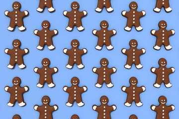 Gingerbread man pattern. Holiday decoration. Festive ornament. Brown cookies collection isolated on blue seamless surface.