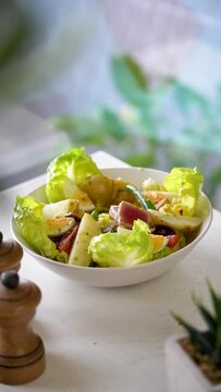 Fresh salade with lettuce, eggs potato and suchi  in a plate on a table.