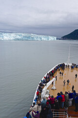 Disenchantment Bay, Alaska, USA: Passengers on the bow of a cruise ship enjoy spectacular views of the Hubbard Glacier.