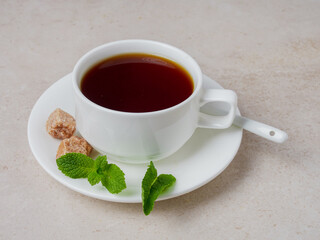 mint tea in a white cup with cookies and lemon on white marble, flat plate