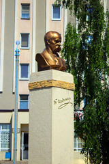 Monument to Taras Shevchenko on the background of the building and green trees