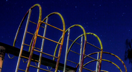 Fototapeta na wymiar Metal structures of sports facilities with ladders against the background of the night starry sky