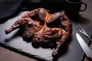 Traditional skoked full chicken on black stone plate © mdbildes