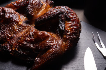 Traditional skoked full chicken on black stone plate © mdbildes