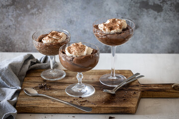 Three glasses of chocolate mousse with whipped cream
