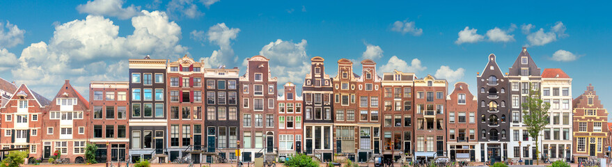 Amsterdam  Long Panorama of famous Amsterdam houses with blue sky. Various traditional houses in the historic center of Amsterdam. Amsterdam, Holland, Netherlands,