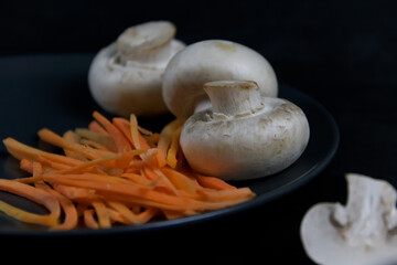 mushrooms, vegetables on a dark background, champignon mushrooms and carrots