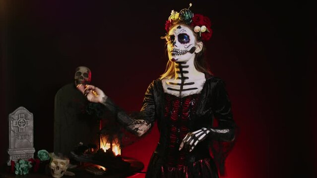 Beautiful horror woman looking at holographic image in studio, using hologram and augmented reality on dios de los muertos. Analyzing artificial intelligence and 3d, celebrating mexican tradition.