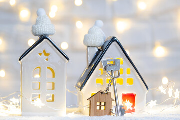 Key to the house with a keychain on a cozy home with a Christmas decor. A gift for New Year,...