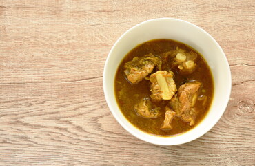 spicy boiled pork bone with curry and basil leaf on bowl