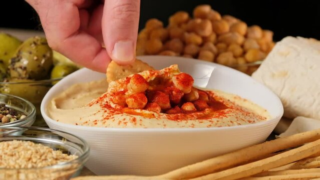 Hummus garnished with chickpeas, olive oil, spices, paprika. Hummus or fava, a hearty snack of legumes. Kosher healthy vegan food. Lean, vegetarian dish
