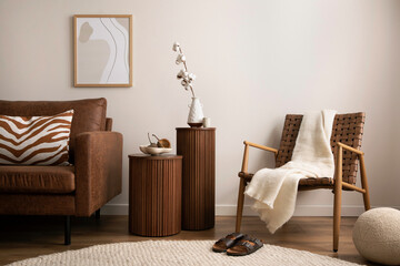 Minimalist composition of elegant and warm space with brown sofa, wooden side tables, rattan...