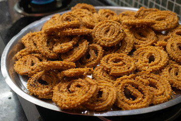 Fototapeta na wymiar Homemade crunchy Diwali snack arranged in plate. Indian traditional snack, deep fry, chakli, muruku, murkoo, vegetarian, spicy, namkeen, chiwda, faral, crunchy, tasty, cholesterol, chakali, murukku.