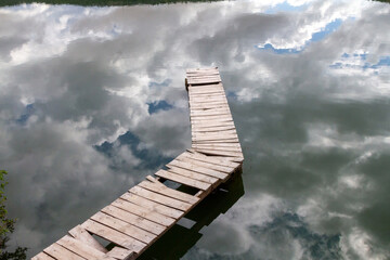 Embarcadero de madera y en el agua reflejado un bonito cielo. Embalse de las Vencías, Segovia,...